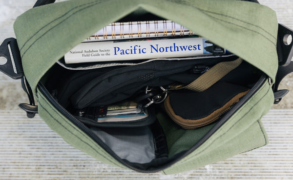 Interior view of the main compartment of the LPD; a notebook, book, wallet, keys, pouch and gloves are shown.